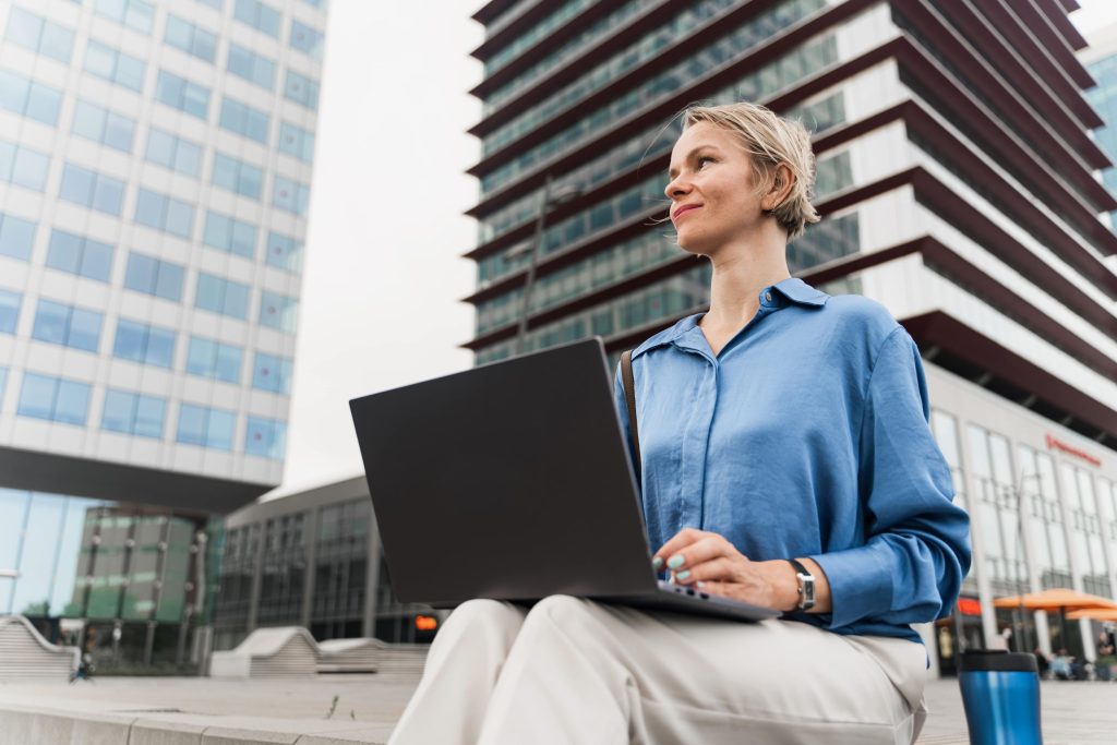 benefits of hybrid IT; businesswoman working on her laptop outside