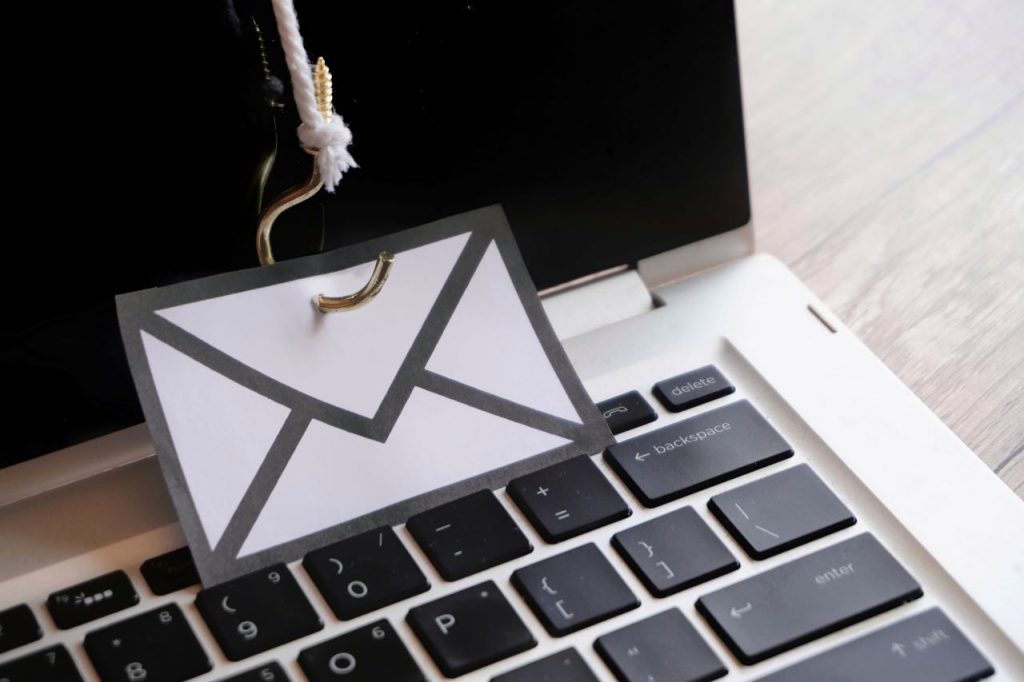 business email compromise attack, Closeup image of mail with hook on top of keyboard.
